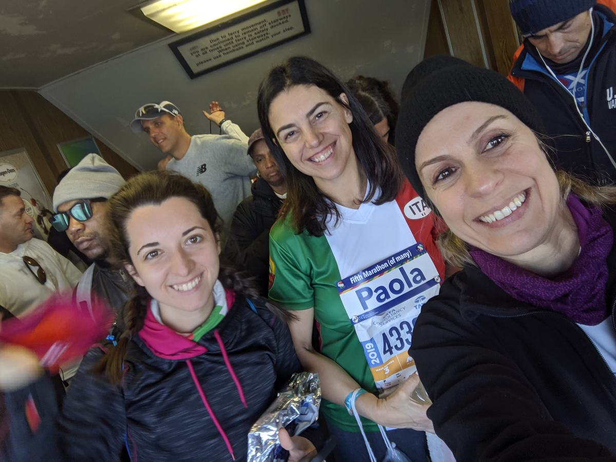 Club members smiling together in their warm-up layers before the start of the TCS NYC Marathon