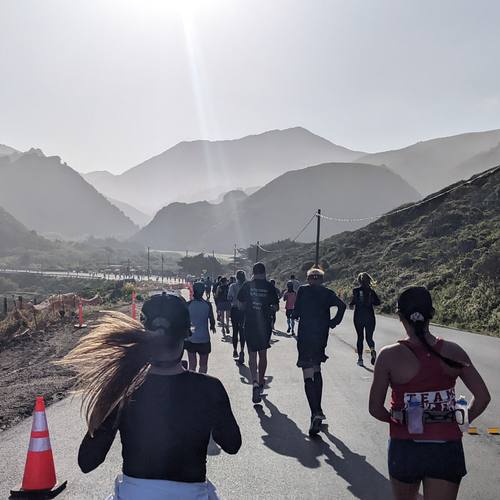 Runners on a road through the mountains at sunrise