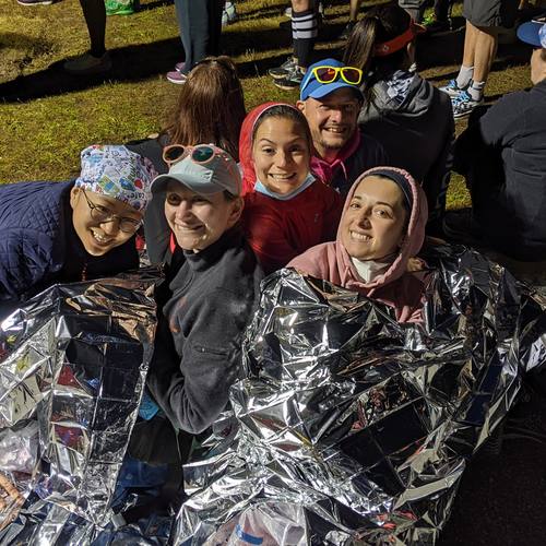 Runners wrapped in foil blankets waiting at a race start